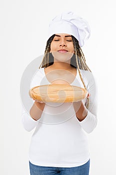 Young attractive african american woman in cooking hat holding empty wood pizza cutting board isolated on white background. Copy