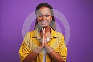 Young attractive African American woman makes gesture of praying person