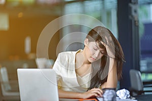 Young attractive Asian business woman sleeping, drowsing or taking a nap at her desk, Tired business woman accountant with bills