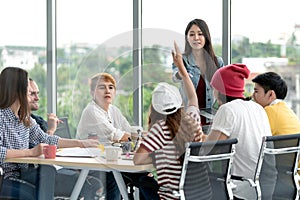 Young attractive asian creative hipster female leader standing at modern office happy talking and brainstorming idea presentation