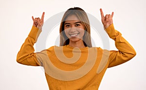 Young attractive asian girl smiling with rock n roll pose in studio