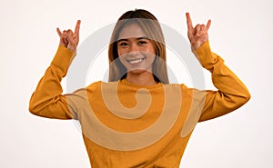 Young attractive asian girl smiling with rock n roll pose in studio