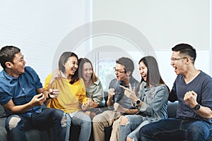 Young Attractive asian group of friends talking and laughing with happy in gathering meeting sitting at home photo