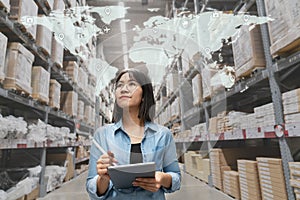 Young attractive asian manager woman looking, picking, replemishment, receiving inventory at store warehouse in warehouse photo