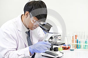 young attractive asian scientist working in chemical laboratory