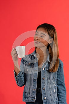 Young attractive asian smiling while holding cup