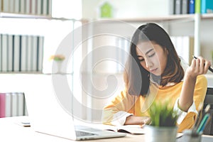 Young attractive asian woman or student working on thesis assignment or studying online in self e-learning education program.