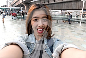Young attractive Asian woman tourist taking a photo of selfie in urban city