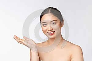 Young attractive asian woman who takes a capsule or pill. Isolated over white background.