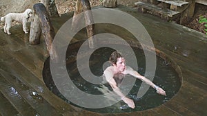 Young attractive awesome man is testing new wooden whirlpool