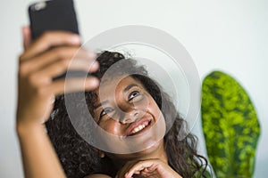 Young attractive and beautiful happy black African American woman taking selfie portrait picture with mobile phone at holidays apa