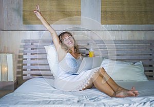 Young attractive and beautiful happy Caucasian woman 30s lying in bed at home using internet working on computer laptop smiling re