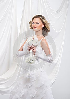 A young and attractive blond bride in a white dress