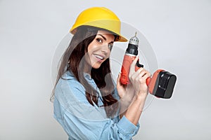 Young attractive brunette with an electric drill