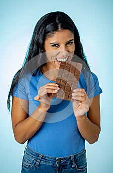 Young attractive brunette feeling joy and guilt at the thought of eating chocolate