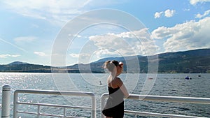 Young attractive brunette woman on the Kelowna lake front enjoying the sunshine. HD 24PS.