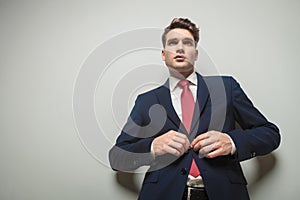 Young attractive business man closing his jacket
