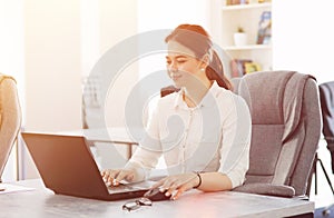 Young attractive business woman working in office smiling looking into laptop