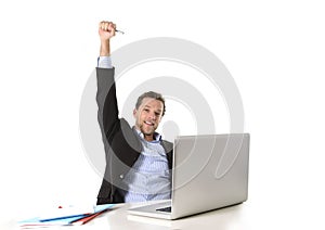 Young attractive businessman happy and hectic at office work sitting at computer desk satisfied celebrating