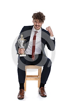 Young attractive businessman holding firmly one fist up
