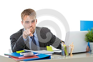 Young attractive businessman working busy with laptop computer at office pointing with his finger