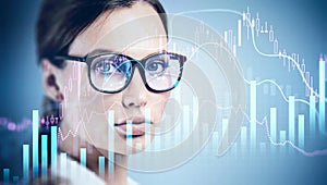 Young attractive businesswoman wearing glasses is watching on financial graph