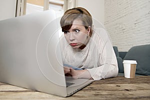 Young attractive and busy woman at home sofa couch doing some laptop computer work in stress looking worried in entrepreneur lifes