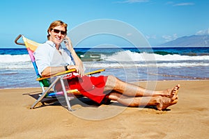 Young Attractive Casual Businessman Relaxing at the Beach Talking on Cell Phone