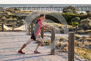 Young attractive Caucasian blond man on his 30s stretching leg i