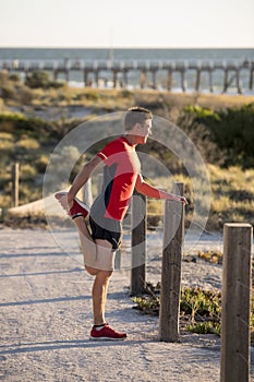 Young attractive Caucasian blond man on his 30s stretching leg i