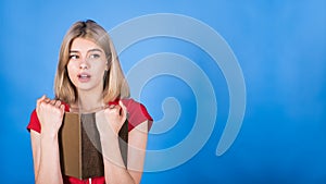 Young and attractive caucasian blonde girl is surprised, reading a book and looking at a copy space for advertising.