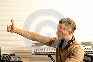 Young attractive Caucasian man musician singer in recoding studio with microphone. Performance arts concept