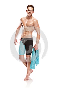 Young attractive caucasian man swimmer with goggles and towel