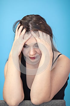 Young attractive Caucasian woman holding head with both hands in despair position. Concept of problem, sadness. Female ungroomed, photo