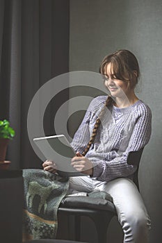 Young attractive caucasian woman resting using browsing tablet computer at home, happy girl relax reading digital gadget