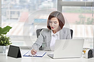 Young, attractive and confident business woman working in office