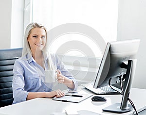 Young, attractive and confident business woman working in office