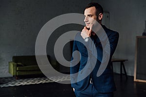 Young attractive and confident businessman in blue suit and black tie.