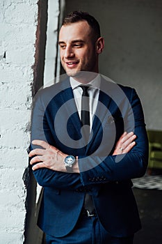 Young attractive and confident businessman in blue suit and black tie.