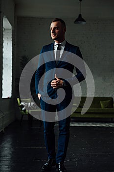 Young attractive and confident businessman in blue suit and black tie.