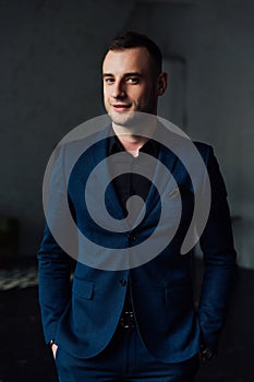 Young attractive and confident businessman in blue suit and black tie.