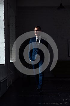 Young attractive and confident businessman in blue suit and black tie.