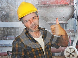 Young attractive and confident contractor or construction worker man with builder safety helmet posing corporate smiling cheerful