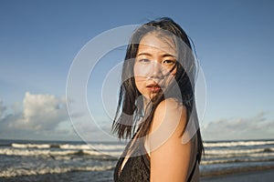 Young attractive and cool Asian Korean woman in swimsuit walking on beautiful beach paradise feeling relaxed enjoying holidays in