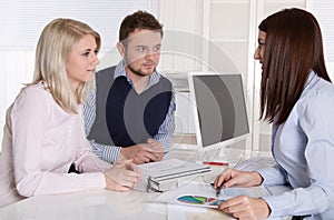 Young attractive couple at consultation with female consultant.