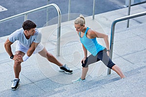 Young attractive couple exercising in stairs