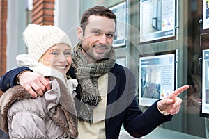 Young attractive couple in front of an agency