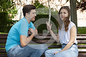 Young attractive couple have an argument over something, outdoor shoot