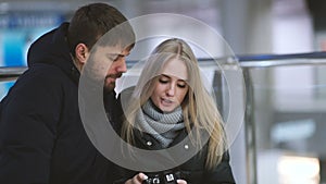 Young attractive couple have fun and view photos on camera in shopping mall
