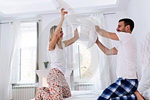 Young attractive couple having fun in bedroom